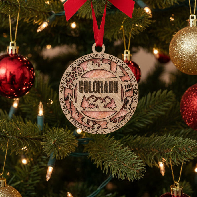 Wooden pendant with engraved text and mountain design on a white background