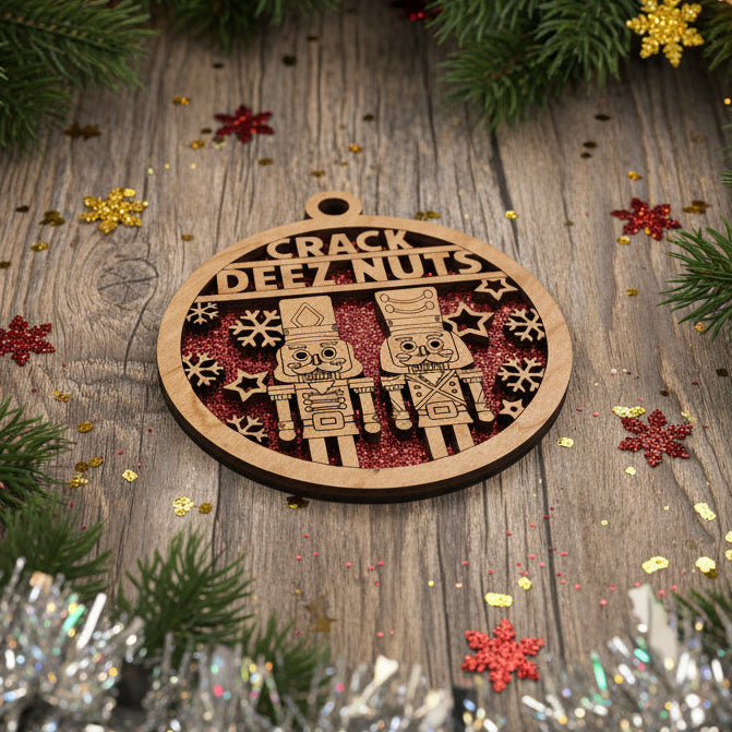 Decorative wooden ornament with ' Crack Dez Nuts' text on a wooden surface surrounded by Christmas decorations.